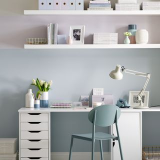 Pastel home office with white desk and floating shelves