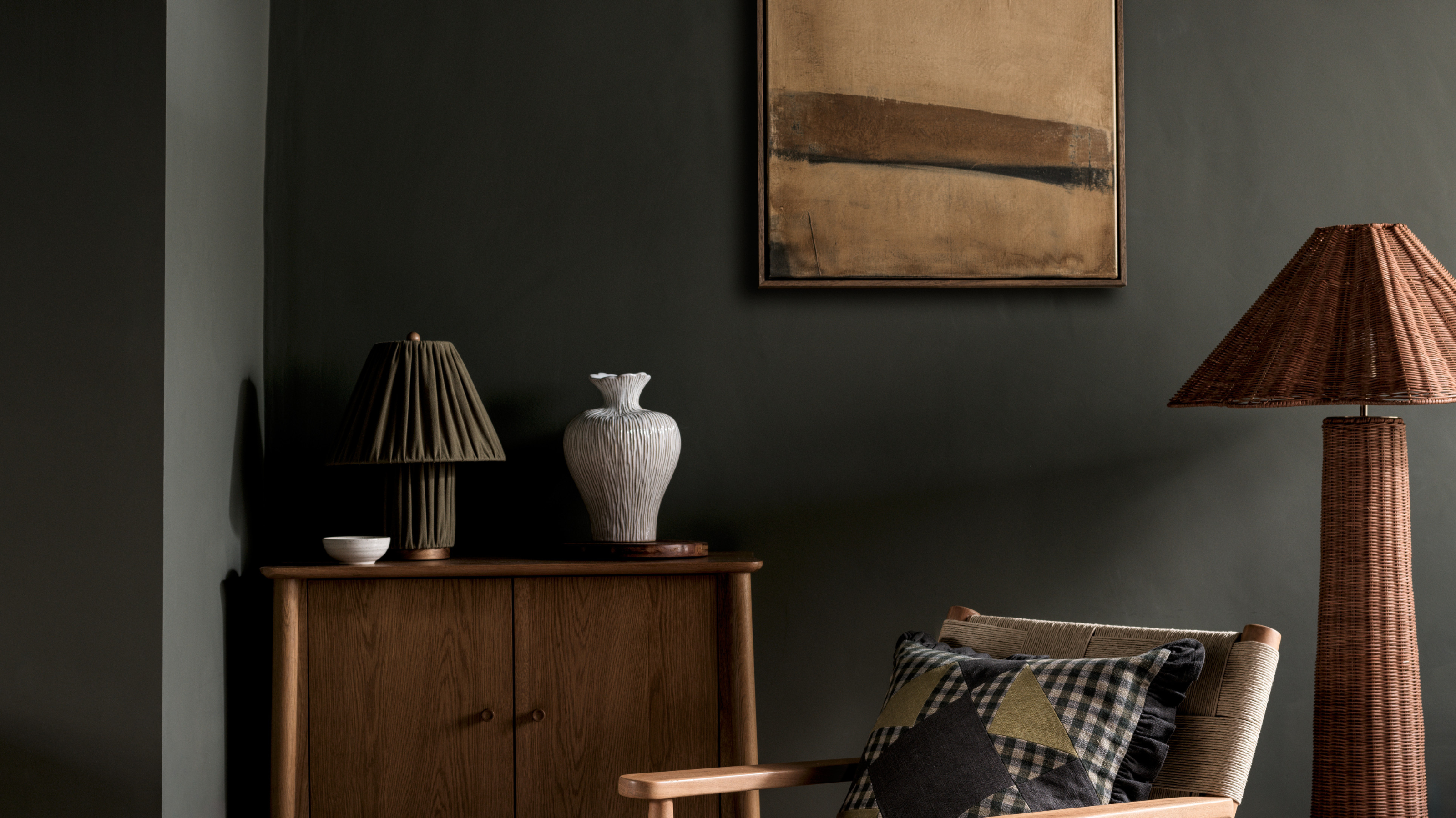 M&S green pleated table lamp in green living room on a wooden cabinet.