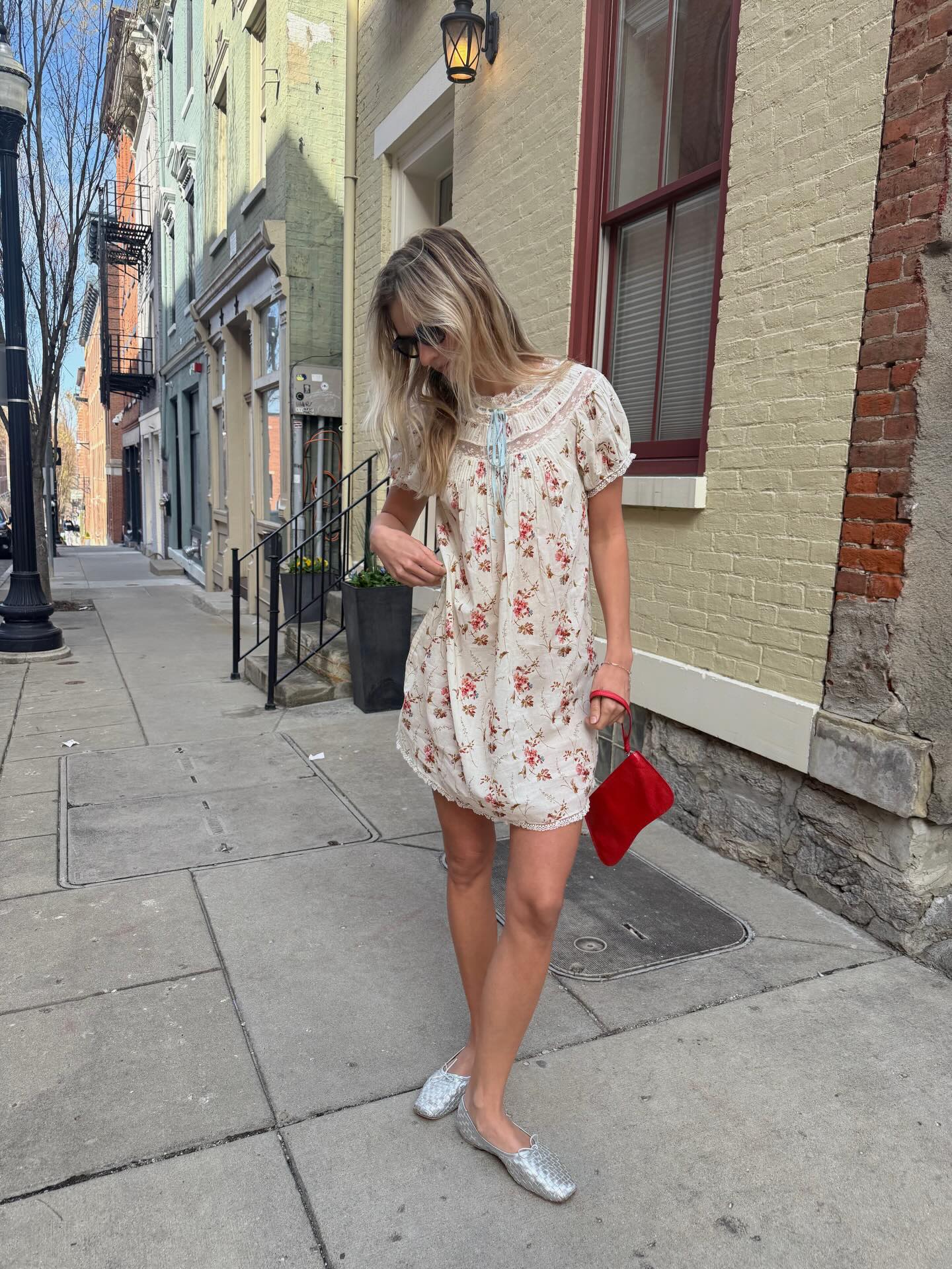 An image of @hannahallen00 wearing a floral babydoll dress from sustainable fashion brand Doen.