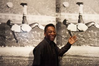 Pele poses in front of Russell Young - Bicycle Kick as he launches Art, Life, Football at Halcyon Gallery in London in September 2015.
