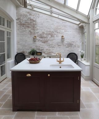 Maroon kitchen island with sink and brass tap
