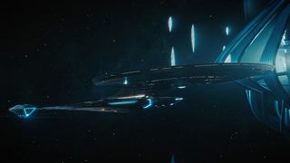 Screenshot from Star Trek: Discovery season 4, episode 9 (Rubicon). It shows a futuristic looking spaceship in space. It has a light blue glow.