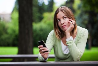 A college woman holds her phone.