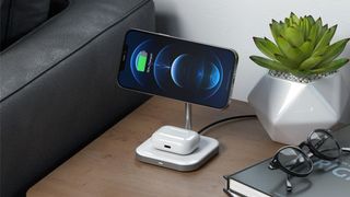 Satechi Aluminum 2-in-1 Magnetic Wireless Charging Stand placed on night stand with iPhone and AirPods charging.