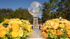 The CME Group Tour Championship trophy in between two bouquets of yellow roses