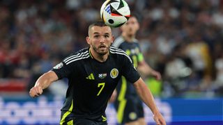 John McGinn eyes the ball in his navy blue Scotland strip.