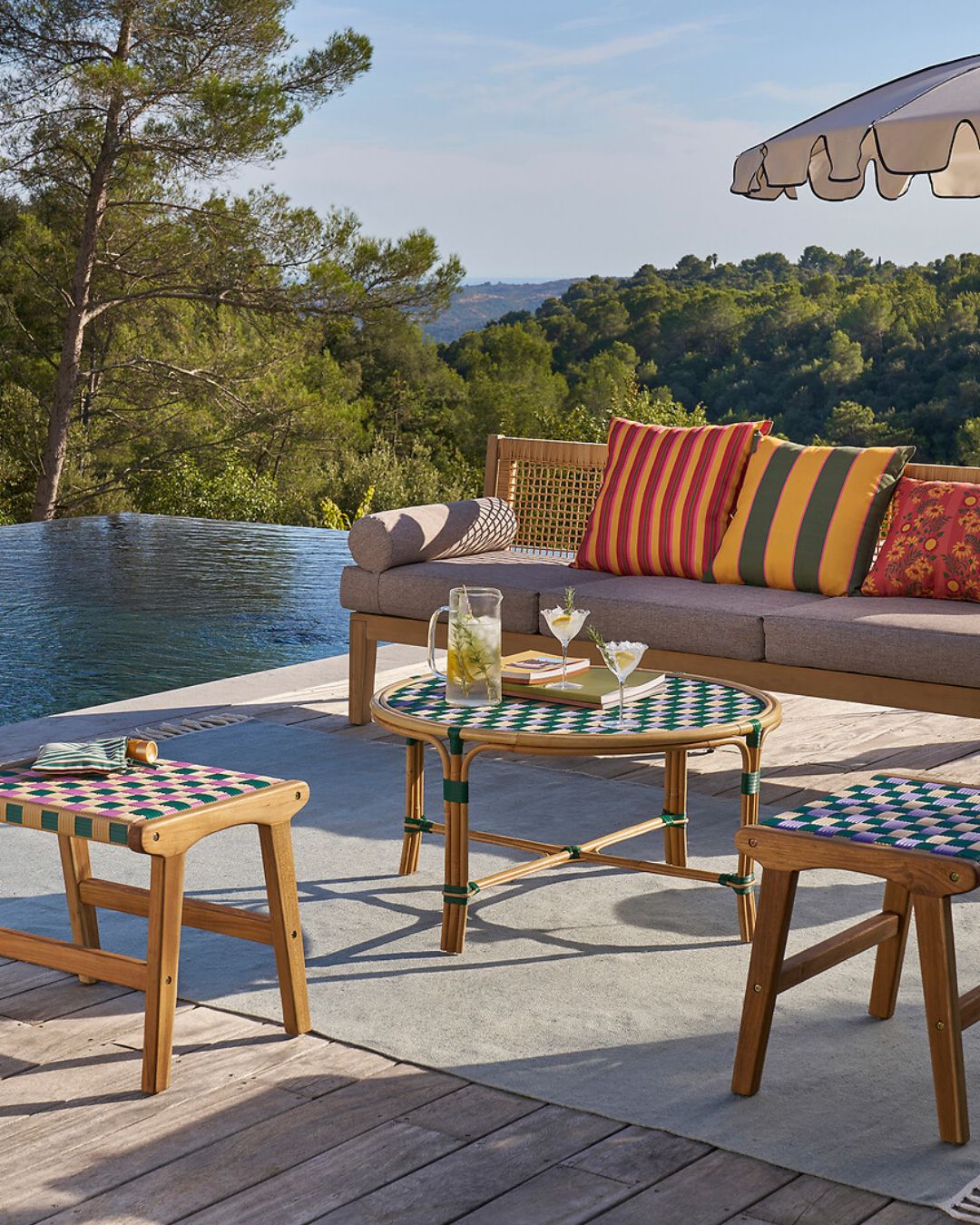 La Redoute Interieurs Bianca Solid Teak/Woven Resin Stool, displayed in a sun-filled pool garden.