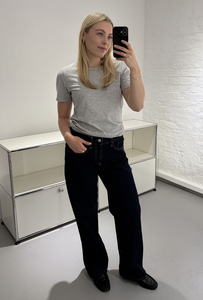 Woman wears grey Tee, blue jeans and black loafers