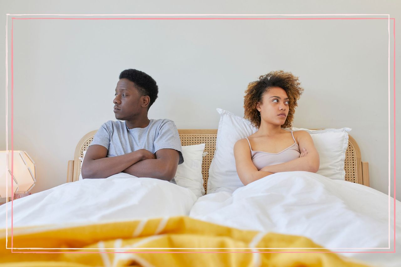 A man and a woman sat in bed looking away from each other 