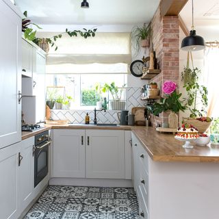 kitchen diner with white cabinets and black and white floor tiles