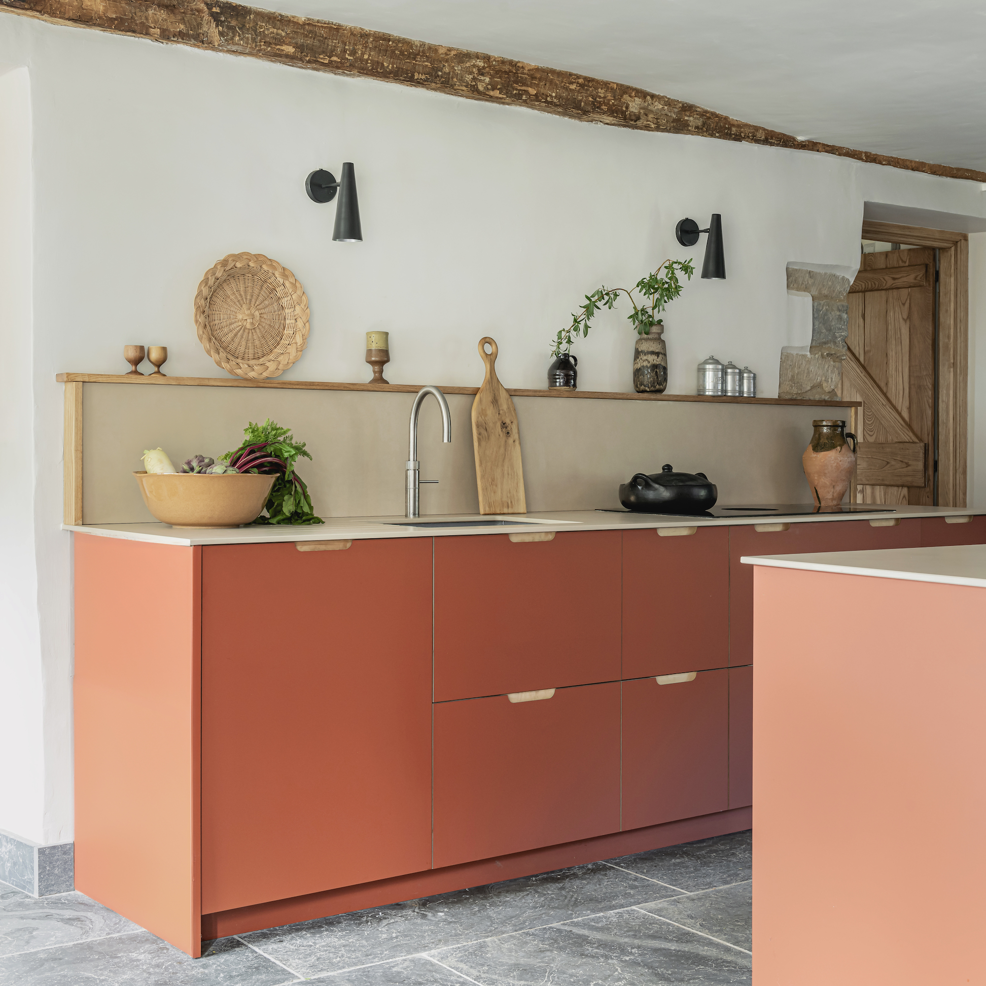 kitchen with orange cabinets and stone floors