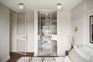 a small ensuite with a glass crittall door
