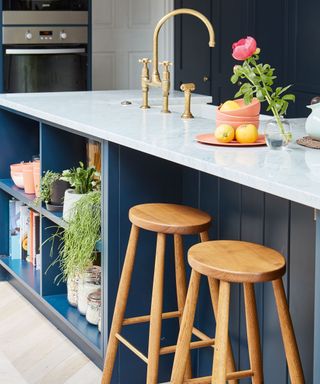 Dark blue kitchen island with sink and bar stools