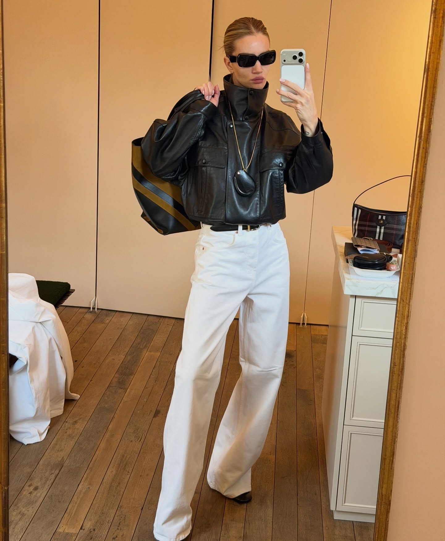 Rosie huntington-whiteley wears white jeans and a black leather jacket.