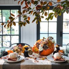 An autumnal tablescape with pumpkins and seasonal foliage