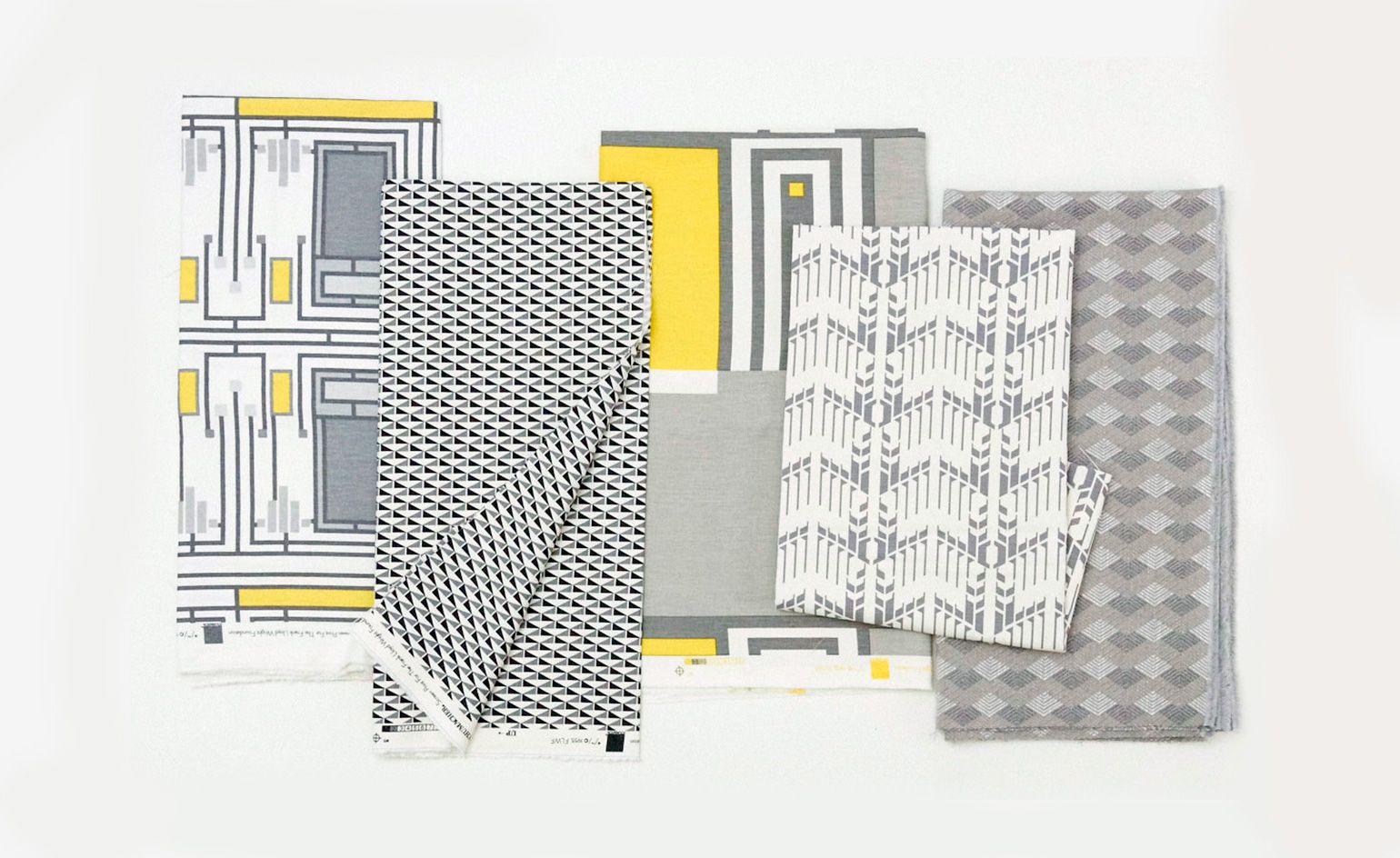 Fabrics with different patterns and colours laid on top of each other.