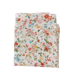 A white folded fabric square with red, yellow, pink, and blue flower patterns with green stems