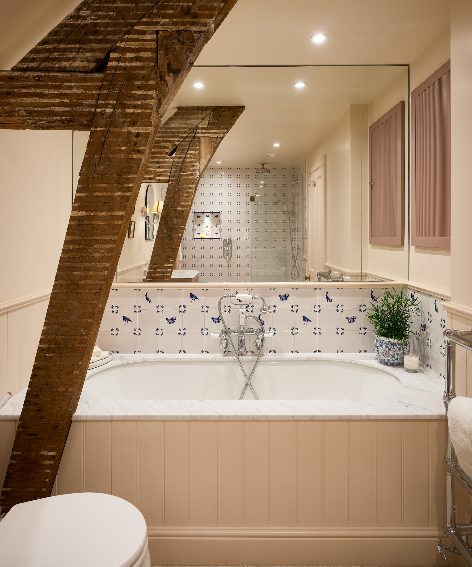 bathroom with wood panelled bath and walls, exposed wooden support strut