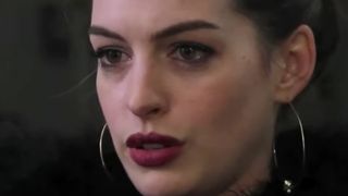 Anne Hathaway with a dark red lip and hoop earrings in 'Don Peyote'