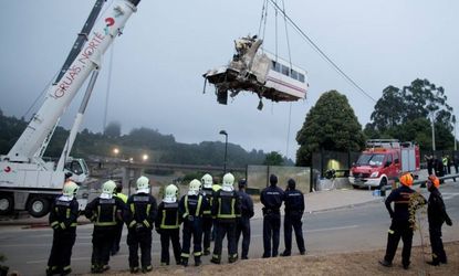A wagon of a crashed train that killed at least 77 people is lifted near Santiago de Compostela, Spain.