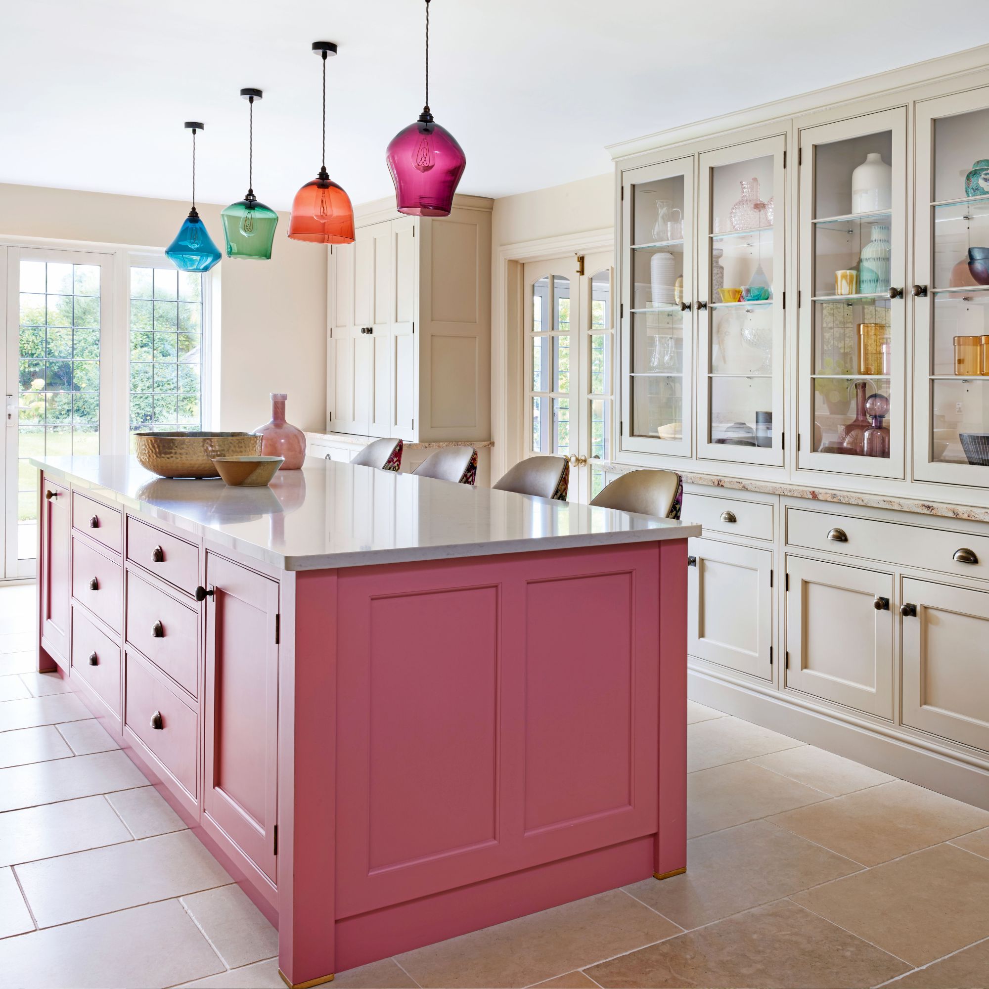 kitchen with cream cabinetry and pink island and mirrored splashback