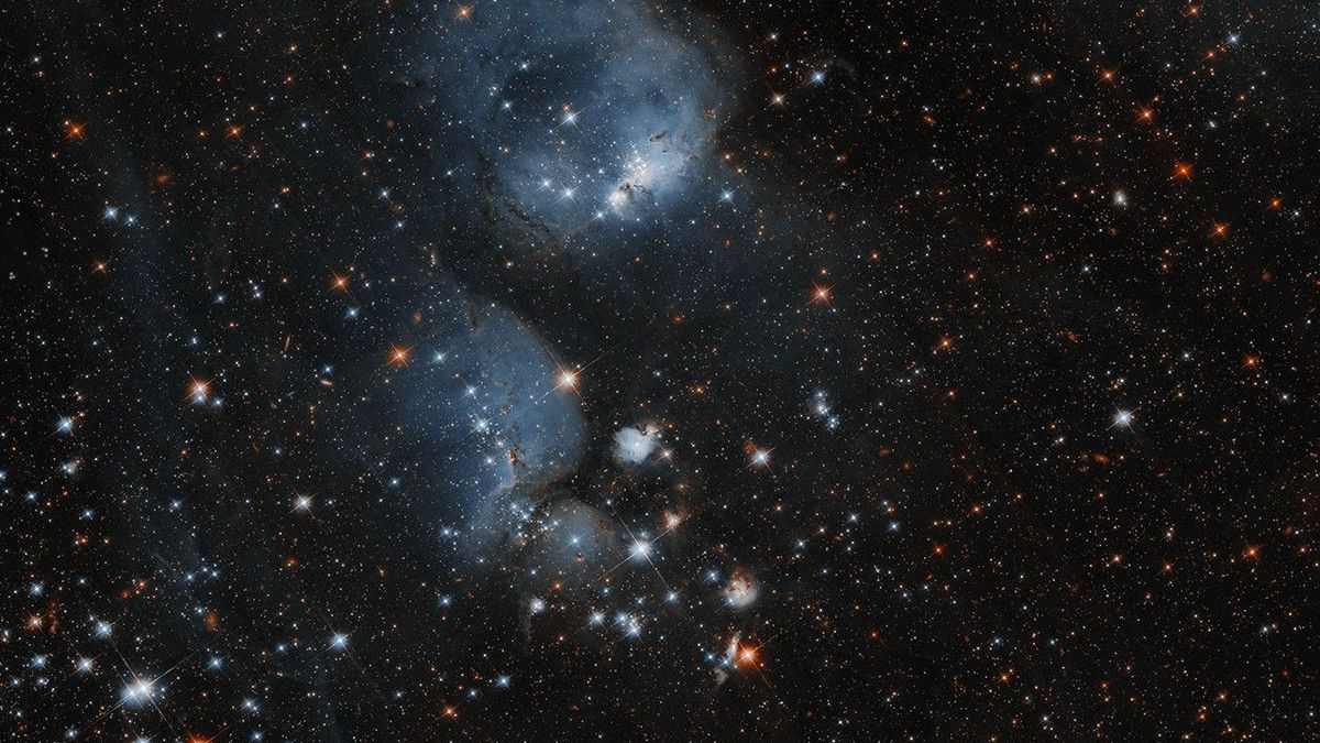 deep-space photo showing countless stars and distant galaxies, as well as two large, silvery-white &quot;cocoons,&quot; which are areas of intense star formation