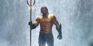 Jason Momoa in his Aquaman costume holding the trident in Aquaman 2018