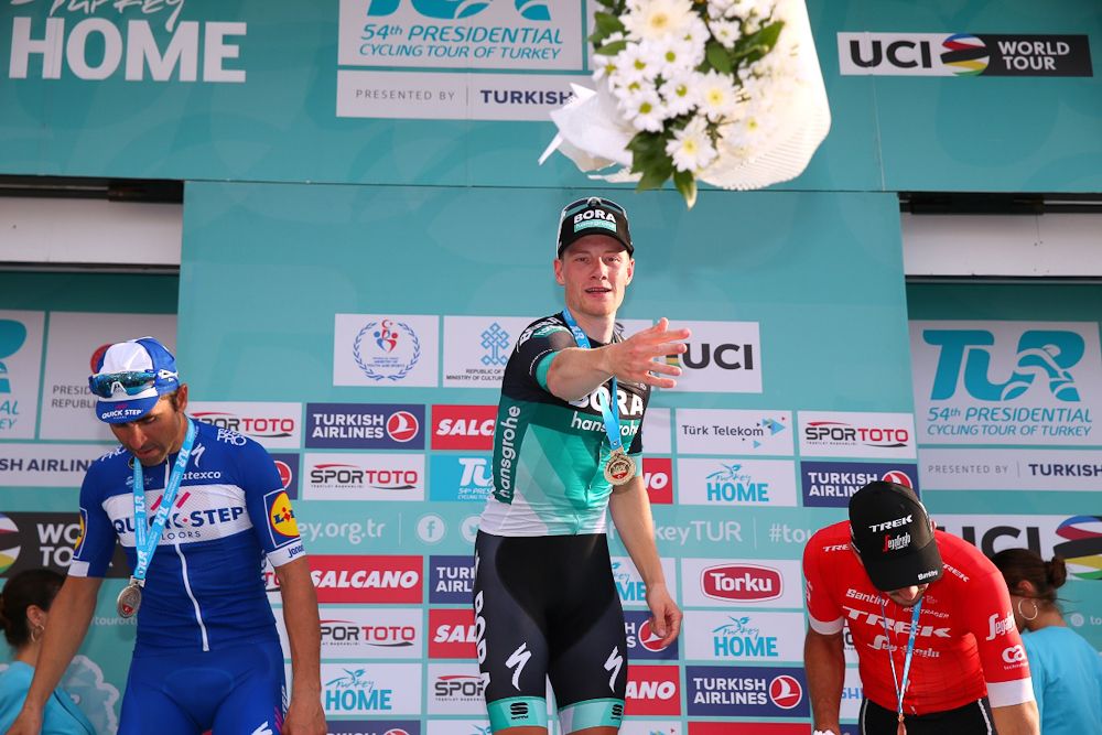 Sam Bennett tosses his bouquet from the podium after winning stage 3 in Turkey