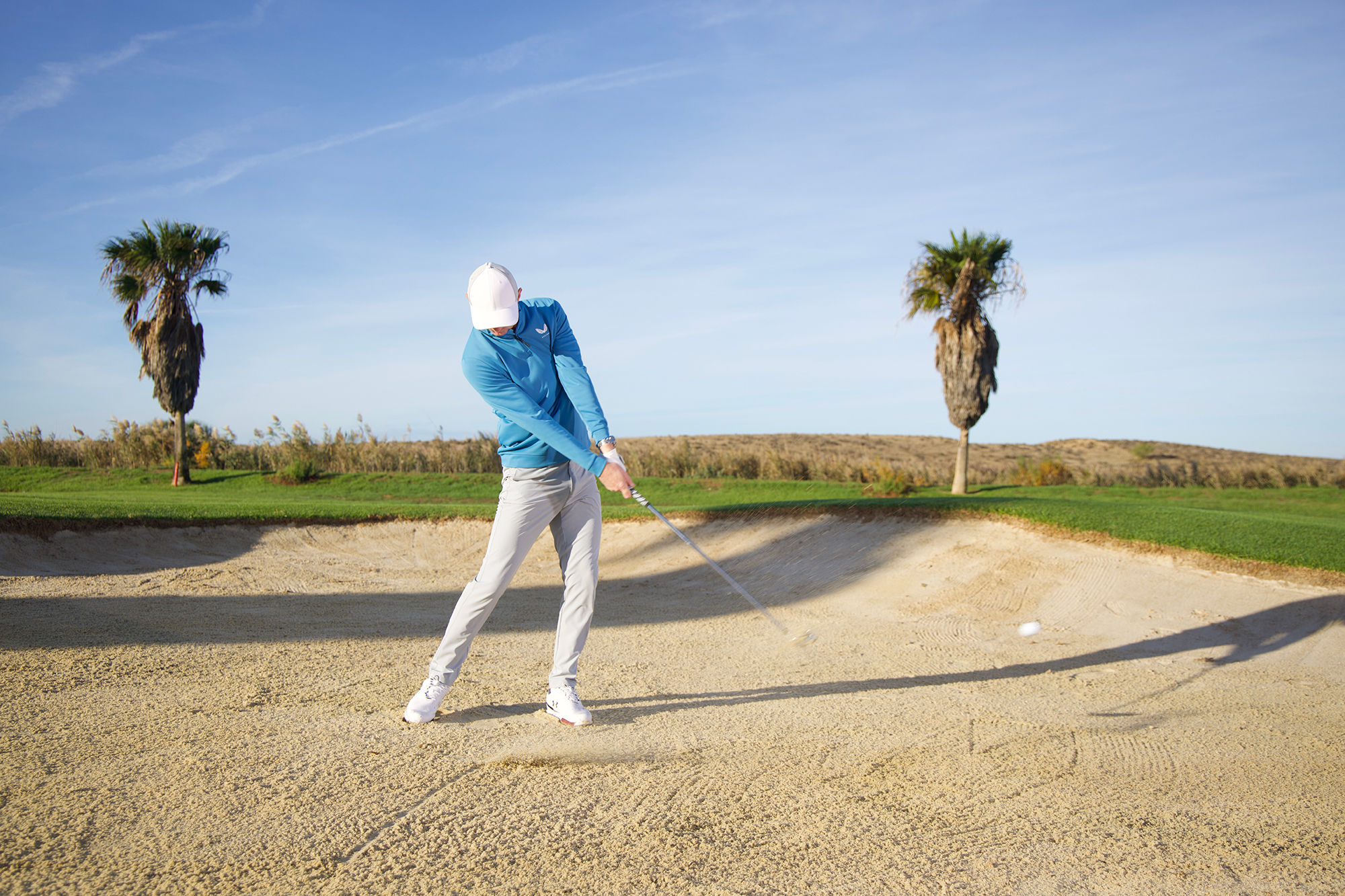 Ged Walters demonstrating the correc technique for hitting a fairway bunker shot with the club just past impact