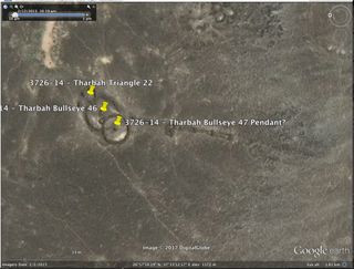 This Google Earth image shows two overlapping bullseyes, with a triangle overlapping one of the bullseyes. There is a pendant that is overlain by a cairn that comes from one of the bullseyes.