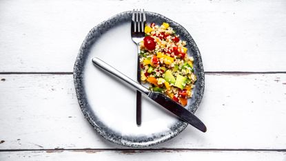 plate with knife and fork organised in a fashion to resemble a clock
