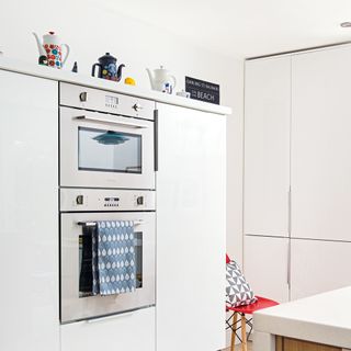 White kitchen with inset ovens and open storage