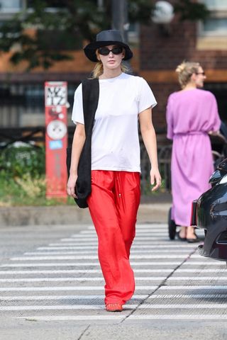 Jennifer Lawrence wears red trousers and red mesh flats.