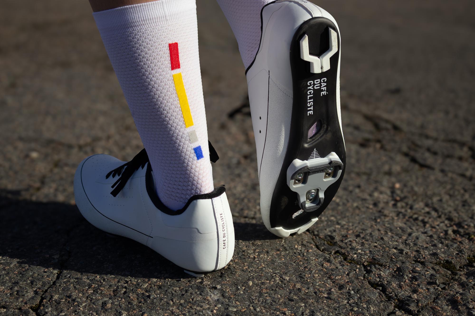 a cyclists feet and shoes showing the sole and cleat on a carbon sole