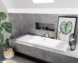 A grey bathroom with square bath, cheese plant and botanical print