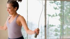 Woman using jump rope indoors