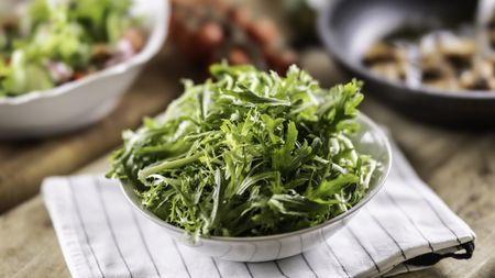 A bowl of frisee salad on a kitchen table