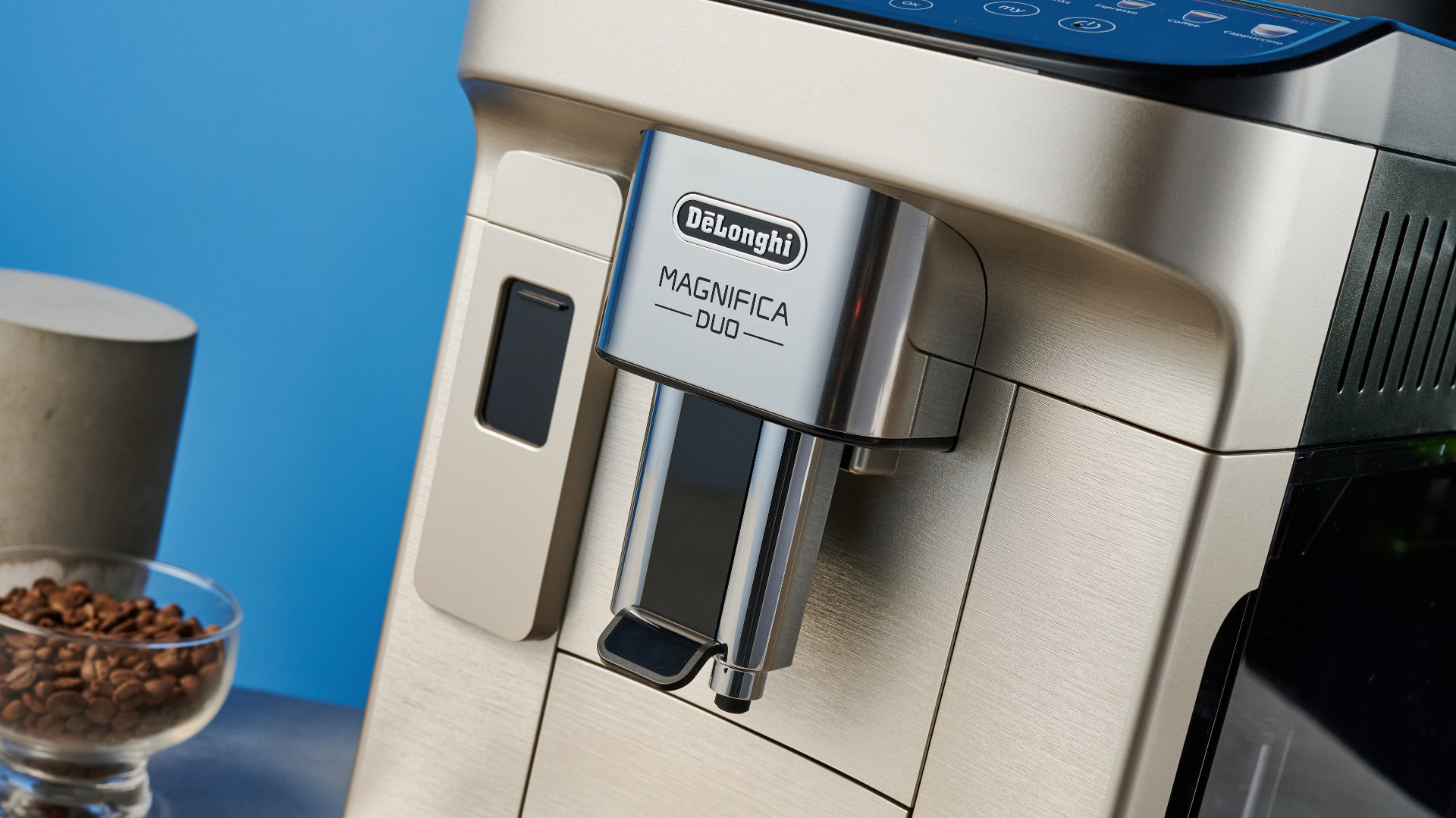 the de'longhi magnifica duo photographed with the blue tom's guide background showing the milk carafe and coffee machine screen