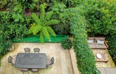 A simpe steel pergola hung with passiflora splits the space. ©Clive Nichols