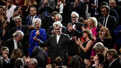 German film director Wim Wenders gestures during the 15th edition of the Lumiere Film Festival award ceremony as the crowd of attendees applauds in Lyon