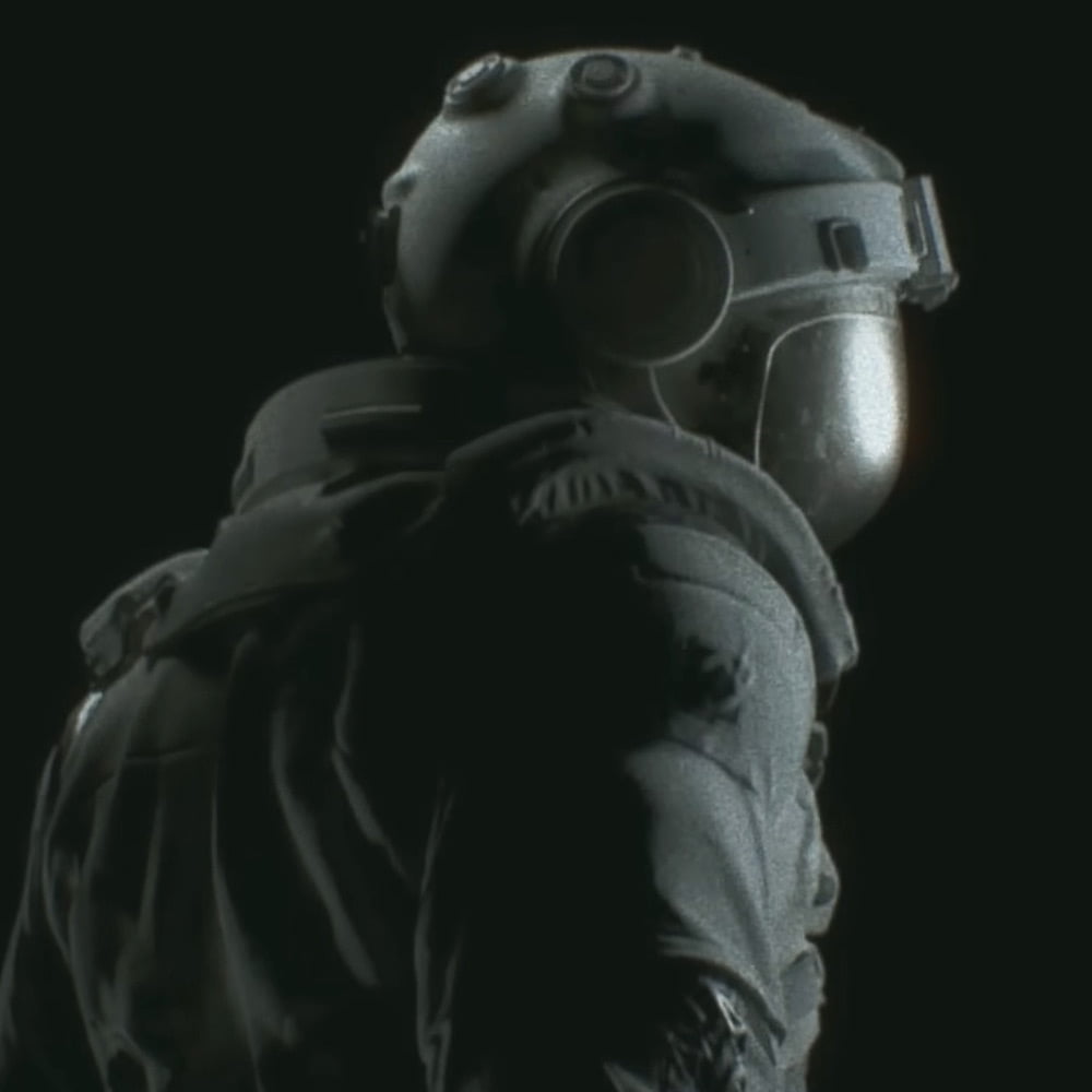 An astronaut figure standing in the darkness with their back turned to the camera