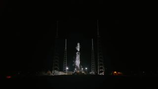 a black and white spacex rocket on the pad at night