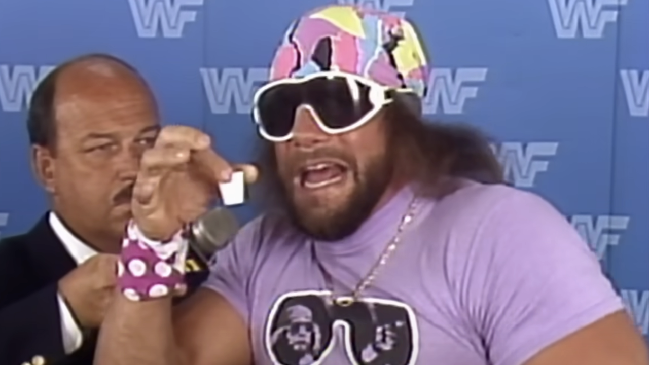 Macho Man Randy Savage in purple shirt interviewed by Mean Gene Okerlund.