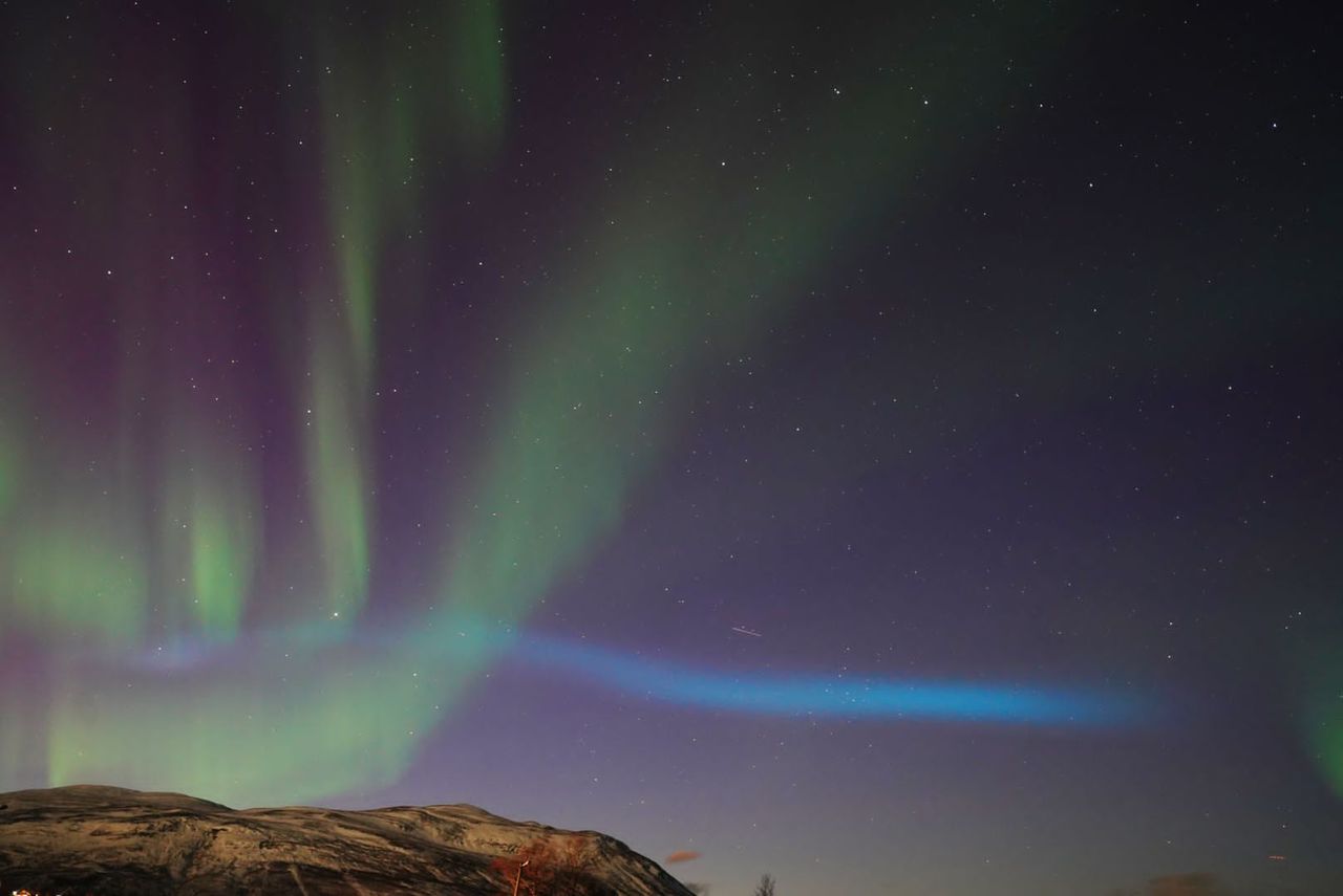 blue ribbon of light appearing over Abisko National Park, Sweden.