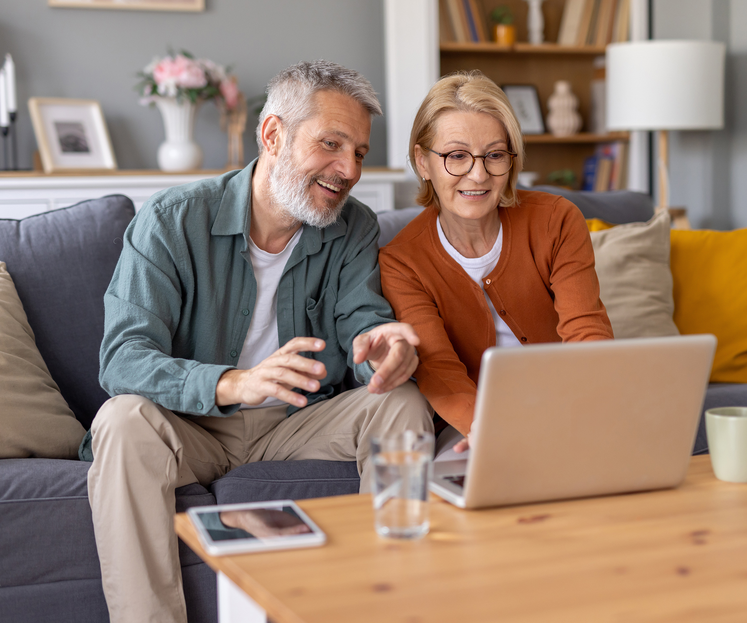 Couple sitting on sofa with laptop