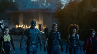 Brianna Hildebrand, Ryan Reynolds, Josh Brolin, Zazie Beetz, and Julian Dennison walking away from a house fire in Deadpool 2.