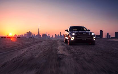 Aston Martin DBX front-on with cityscape