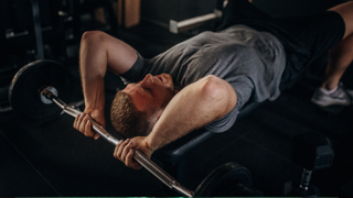 Man performing laying tricep extensions