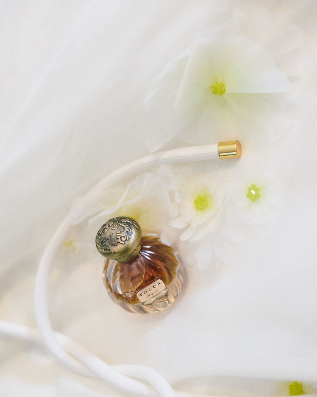 Bottle of perfume on a white sheet.