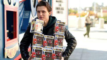 tom holland holding a bunch of spiderman funko pops